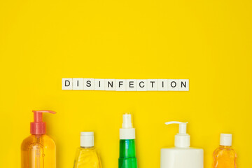 Disinfection due coronavirus. Flat lay cleaning bottles and disinfection word made of wooden letters