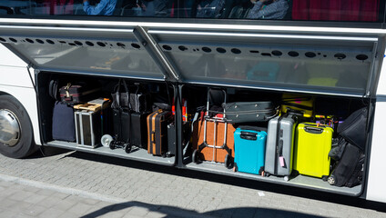 Travel suitcases in the luggage compartment of a passenger bus.
