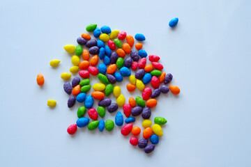 Multicolored dragees on a white, shiny surface.