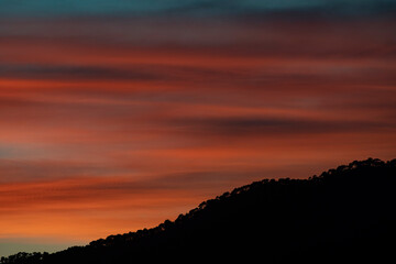 Puesta de sol de naranja intenso sobre montañas 