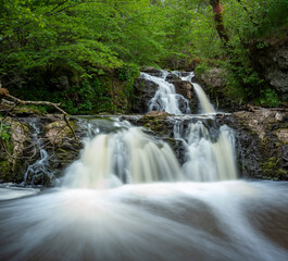 Stunning Slow falling Water Hallamolla Waterfall in lush rural Forest during springtime in Skane Osterlen near national park Stenshuvud, South Sweden.  Long Exposure Waterfall.
