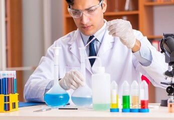 Young handsome biochemist working in the lab