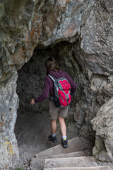 Woman On Hiking Trail Enters A Cave In Ötschergräben In Austria