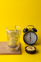 Conceptual food photo of healthy snacks on minimalist bright yellow background: vegan lemon pie and herbal tea