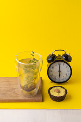 Conceptual food photo of healthy snacks on minimalist bright yellow background: vegan lemon pie and herbal tea
