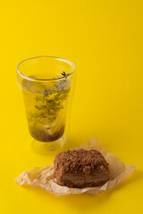 Fashion food photography: dietary russian medovik on craft paper and transparent glass of buckwheat tea