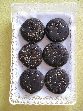 galletas de harina de algarroba seis, 6, cubiertas de frutos secos en bandeja con papel de blonda blanco para reposter&iacute;a Dulces artesanos, caseros, ecol&oacute;gicos
