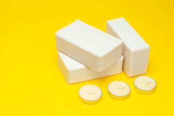 Concept of purity concept. White soap, scented candles on a yellow background.