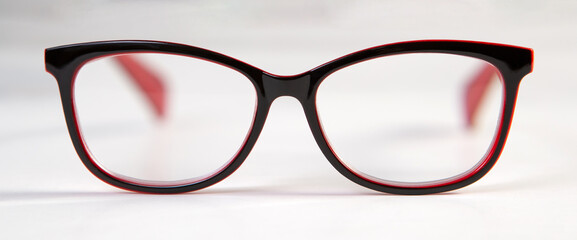 Black glasses for vision with red bows on white background.