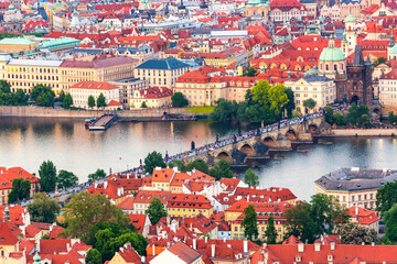 Houses with traditional red roofs in Prague with Charles Bridge, Czech Republic.