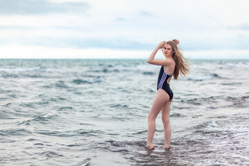 Fototapeta na wymiar Beautiful and young blonde girl in a swimsuit relaxing on the sea