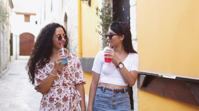 Multi-ethnic teenage girls drinking granita frozen drink on summer holidays