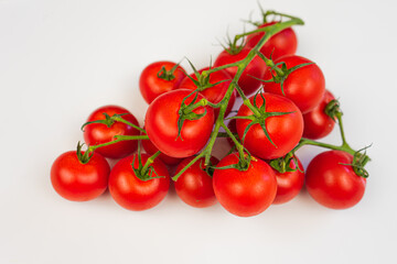 Cherry tomatoes on a branch close-up white background