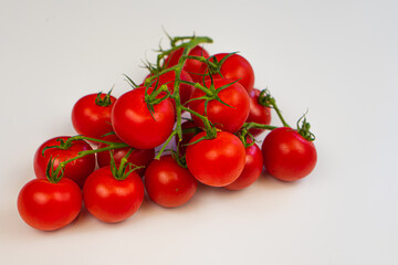 Cherry tomatoes on a branch close-up white background