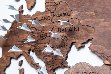 A wooden map of the world is glued to the wall on it marks with countries that have visited