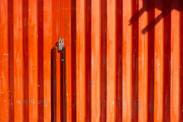 Red metallic ribbed striped  background. Wall of a traditional market, building. High fence.