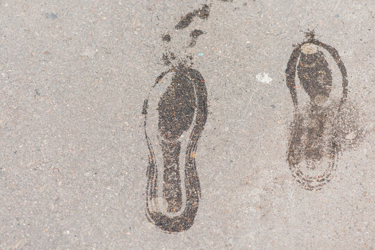 imprint of wet soles on the asphalt