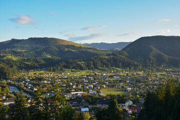 City in the valley against the backdrop of several mountains and blue sky with clouds