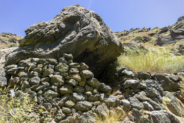 Old stone shelter in mountains for shepherds. Ancient sanctuary in wild nature.