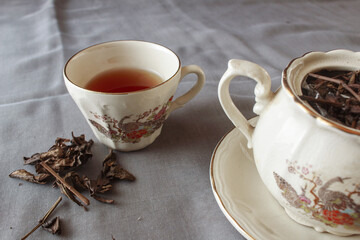 cup of tea and teapot on gray background. antique cup and teapot