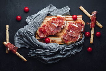 Ham still life cut with bread, oil and tomato. Concept of gastronomy