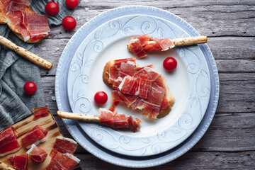 Ham still life cut with bread, oil and tomato. Concept of gastronomy