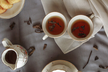 Two cup of tea with teapot, on gray background. Antique cup and teapot, 