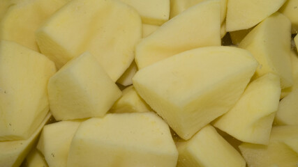 Cut raw potato cubes in water with tiny bubbles. Background. Macro photo, closeup