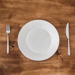 empty plate with knife and fork on wooden background