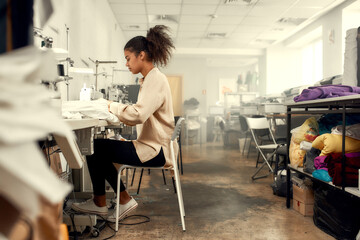 Sew On And Sew Forth. Full-length shot of young woman seamstress sitting and sewing. Dressmaker...