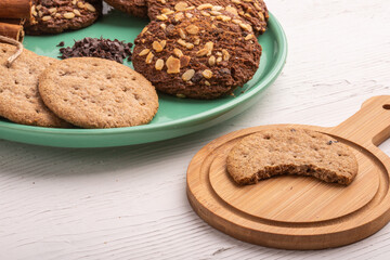 Stack of tasty chocolate cookies on white wooden table.
