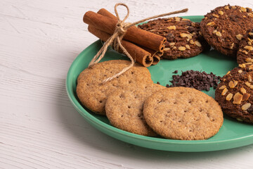 Stack of tasty chocolate cookies on white wooden table.