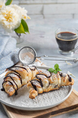 Homemade croissant served with black coffee or americano. Delicious breakfast with fresh croissant and coffee. Croissant and black coffee and chamomile with copy space in top view or flat lay style.