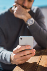 chico joven utilizando su celular para enviar un mensaje