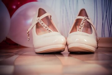 beige bride wedding shoes standing on the floor in the apartment