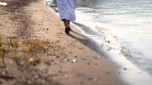 Jesus walking towards us, on the seashore, medium shot