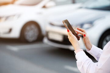 Close up woman hands using mobile phone, communication or online application, standing near car on...