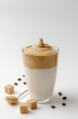 Dalgona Coffee Iced, a Korean whipped black instant coffee with milk, on a white background. Copy space.