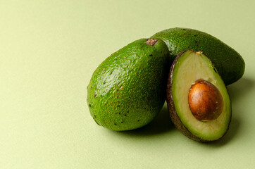Half avocado on pastel green background. Minimalism and objects on a simple background.