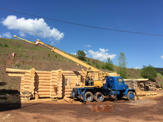 Świerki, Poland - May 27 2020: construction site, building houses from wooden piles. crane sets wood logs house construction © Wiktoria