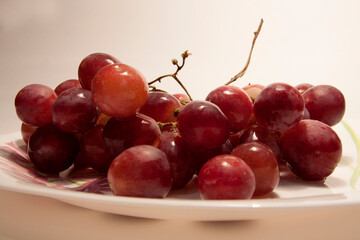 beautiful ripe juicy grapes on a white plate close-up on a white background