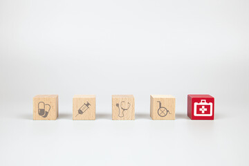 Cube wooden toy blocks with medical and first aid kid icon. Concepts of illness treatment and health insurance.