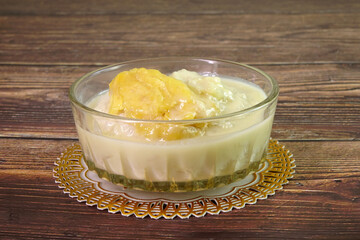 Durian sticky rice in coconut milk and durian creamy sauce. One of most famous Thai dessert in summer of durian season. Selective focus, space for texts