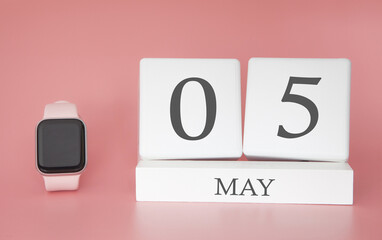 Modern Watch with cube calendar and date 05 may on pink background. Concept spring time vacation.