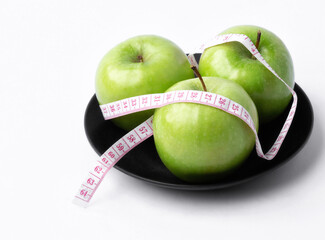 green apple with measuring tape on white background, healthy food concept