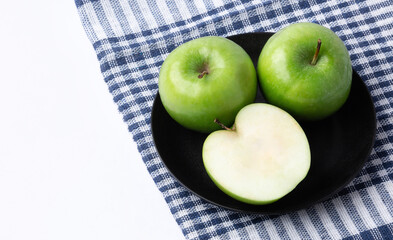 Fresh green apples in a dish on white background