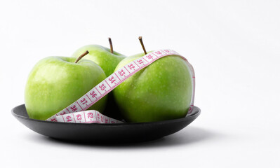 green apple with measuring tape on white background, healthy food concept