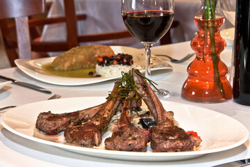 Chuletas de carne de cordero frito con arroz risotto sobre mesa de restaurante