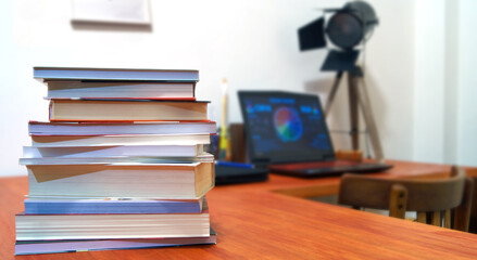 Books stacked on the computer desk.