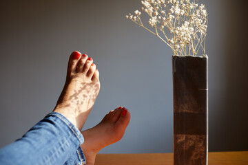 sombra sobre pies de chica joven encima de la mesa